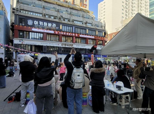 시민들이 인플루언서 크림서현과 랜덤댄스 챌린지 참여자들의 공연을 관람하고 있다.