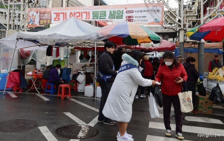 경상원이 여주한글시장을 방문한 도민들에게 '통큰 세일' 홍보물을 나눠주고 있다.