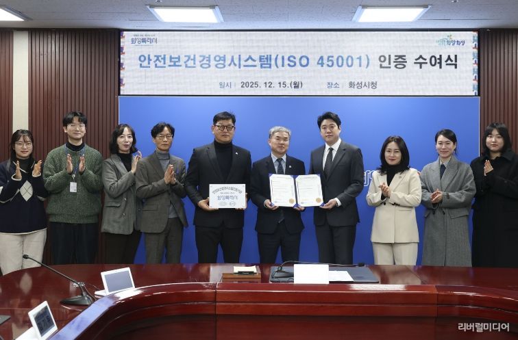 정구원 화성특례시 제1부시장 및 안상현 ISO 45001 선임 심사원 등 관계자가 안전보건경영시스템 인증식에서 기념 촬영을 하고 있다