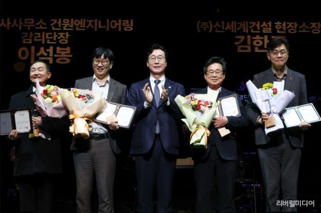 정명근 화성특례시장이 화성예술의 전당 개관기념 제야 콘서트에서 유공자들에게 특별 공로패 및 감사패를 전라하고 기념촬영을 하고 있다.